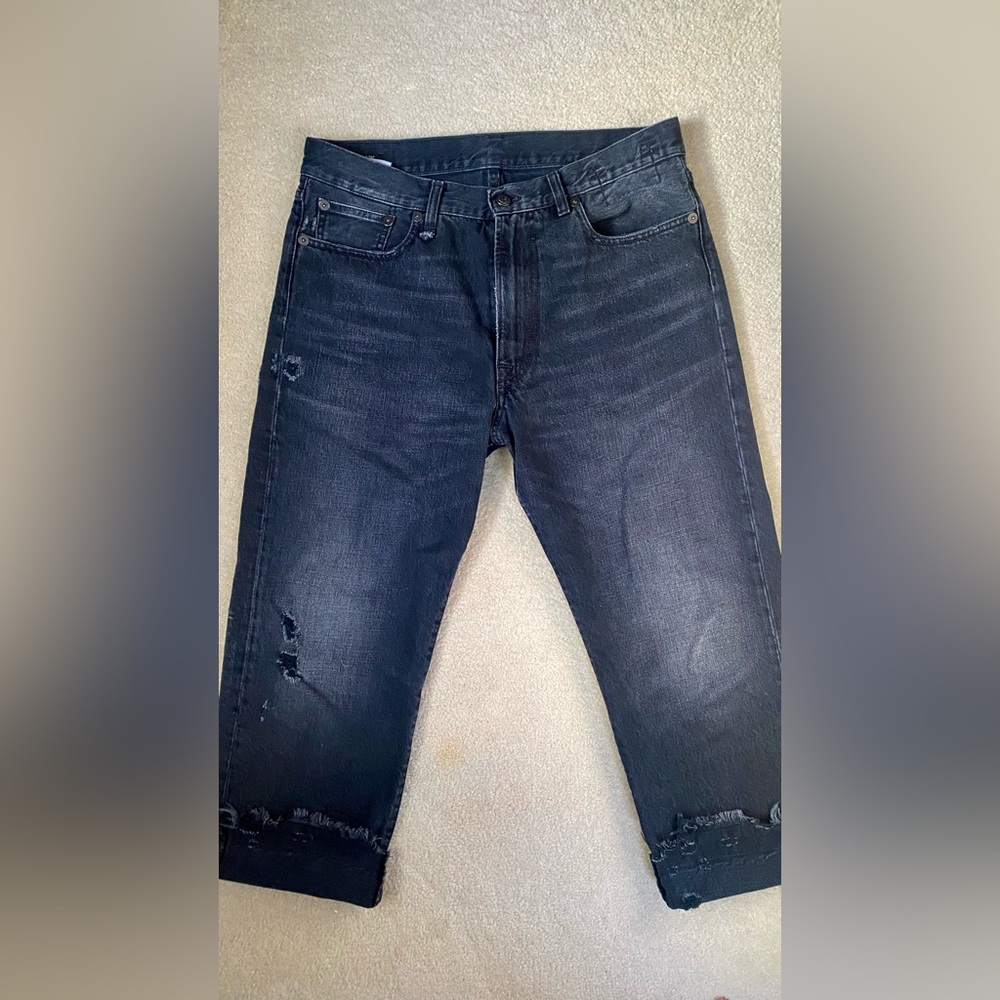 Non-stretch denim jeans. Fading, fraying, and distressing throughout.